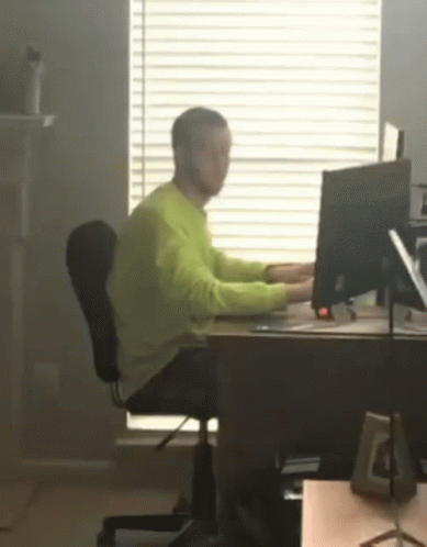 a person is sitting at a desk with a laptop