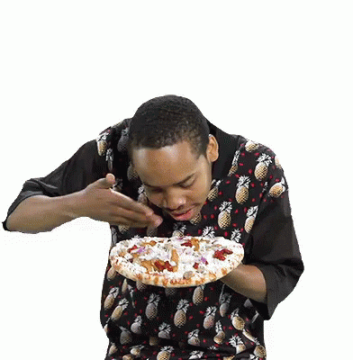 a man standing in front of a white background eating a cake