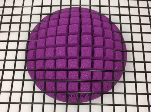 a purple sponge laying on top of a metal grid