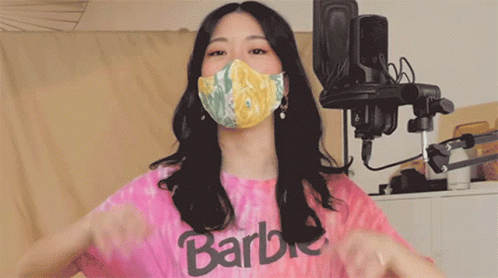 a woman with black hair, wearing a t - shirt and mask