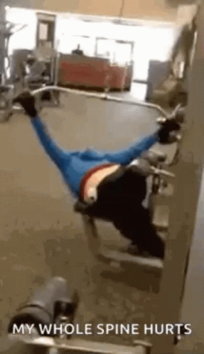 a man in yellow is laying down with a gym equipment