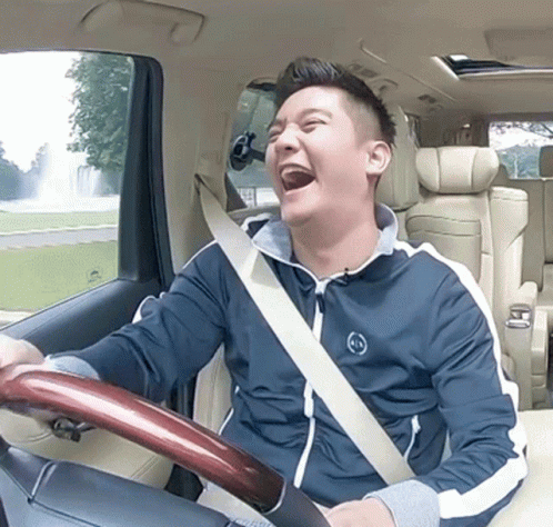 a man driving a car making a surprised face