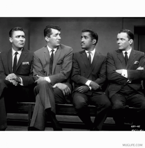 five men in suits sit on a bench