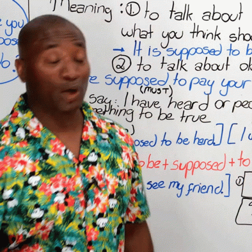 a black man is standing next to a chalkboard that reads talking