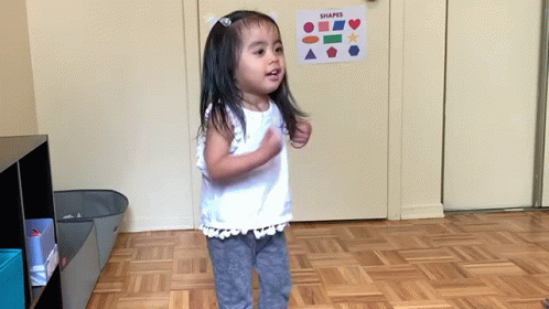 a little girl that is standing in the middle of the room