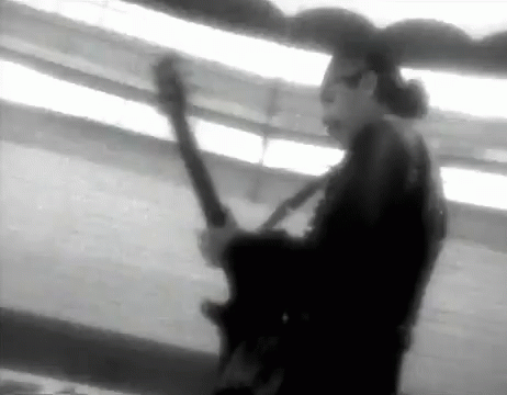 a man plays guitar while walking in a blurry po