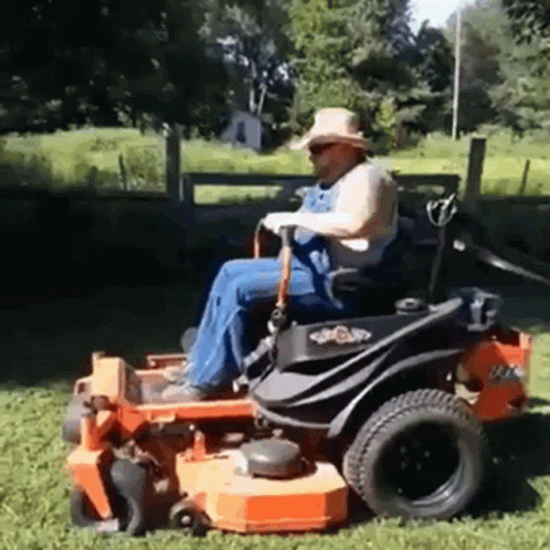 a man is riding on a riding mower on the grass
