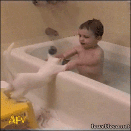 the  in the bathtub is holding the baby while playing with his hands