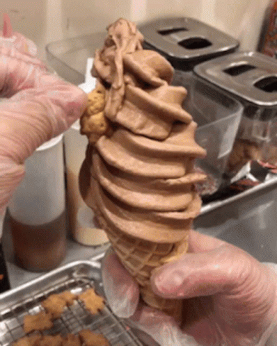 a man preparing ice cream and putting it in an ice cream cone