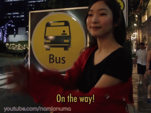 the lady with a bus sign has her arm around her waist