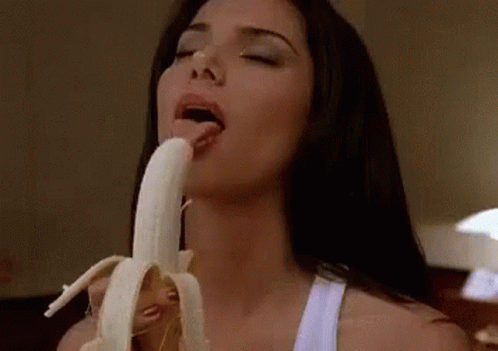 a woman eating a banana on a bed