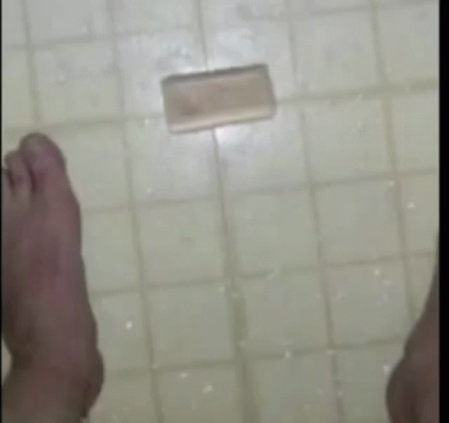 two feet standing in the floor in front of a tile