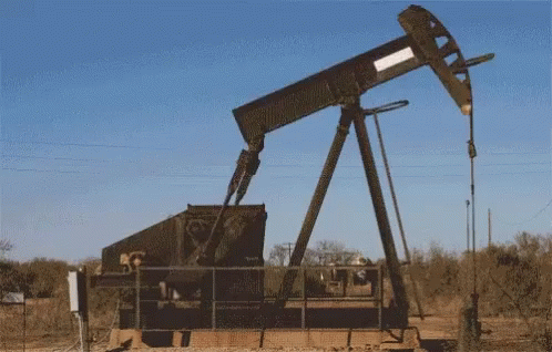 oil pumps are near the ground during an orange sunset