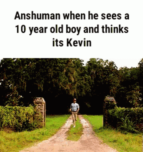 a person stands at the end of a narrow road and a gate behind him