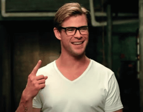 a man that is wearing glasses has his thumbs up