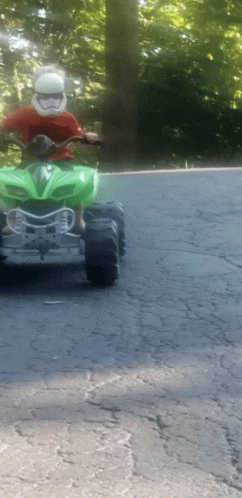 a person riding a toy four wheeler with a helmet on