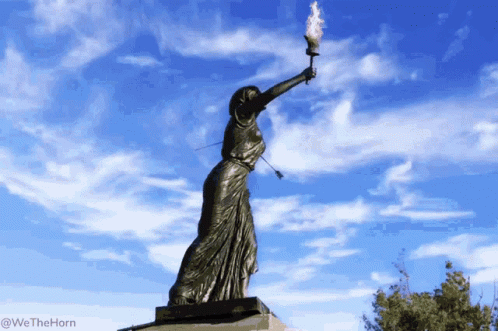 the statue is holding a torch in her hands