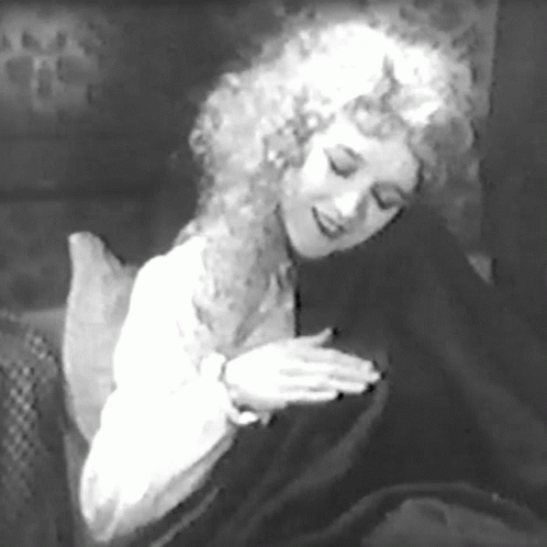 a woman with curly hair wearing a black robe