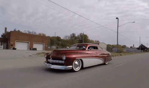 a classic car is running down the road