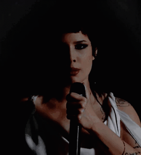 the female is holding a microphone and performing
