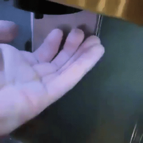 person using a piece of machinery with their hand