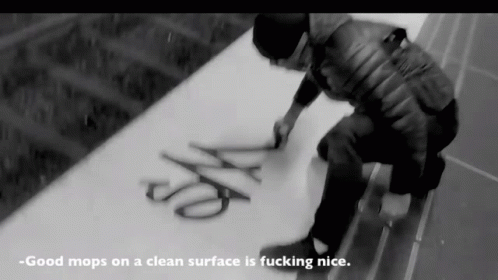 a man standing over scissors that read good mops on a surface ing nice