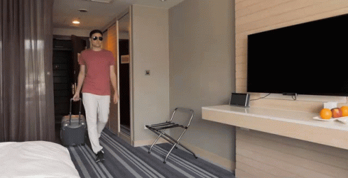 a person walks into a el room with luggage