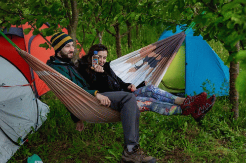 a man sitting in a hammock with a mask on