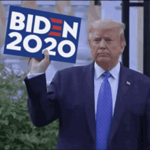 trump holding up a campaign sign that reads biden, and an image of a blue man's face with a red suit