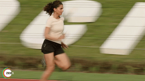 the woman is running through a blurry field