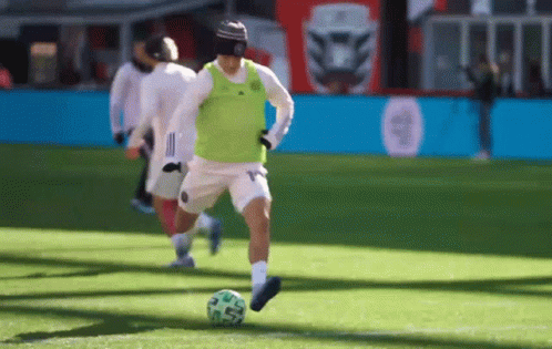 a man with soccer gear on running towards a ball
