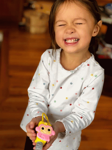 a child holding a toy with its eyes closed