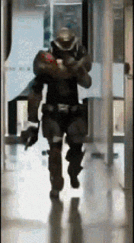 there is a man in a motorcycle suit walking through a building