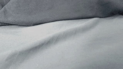 black and white pograph of bed with sheets and pillows