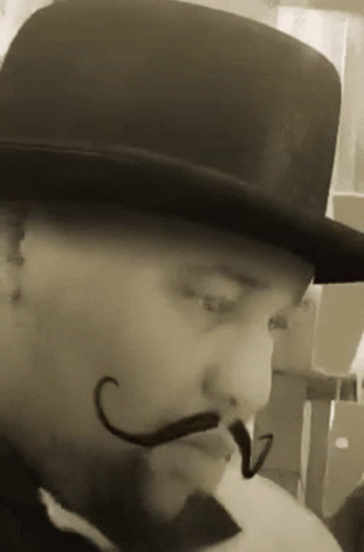 a man in a hat and moustache with a mustache
