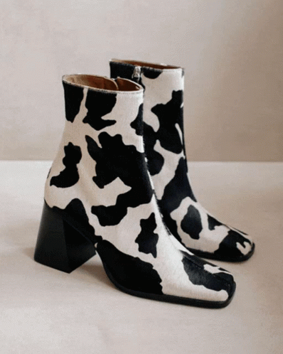 a cow print booties sits on the floor