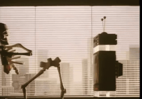 two robots in front of windows looking out the window