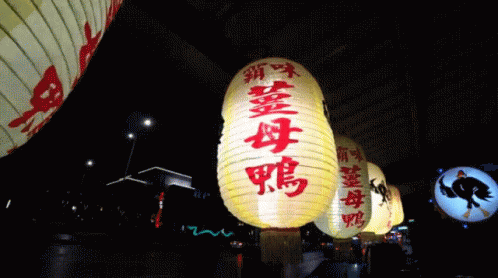 three large lanterns lit up in the night