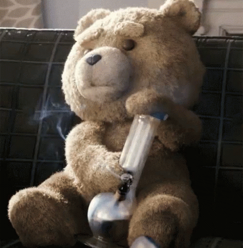 a very cute blue stuffed teddy bear with a pipe in its mouth