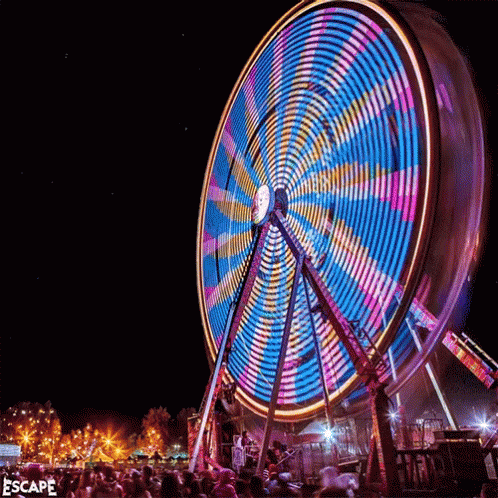 a carnival wheel in the dark with people