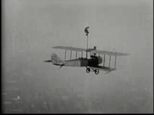 an old airplane flying through a foggy sky