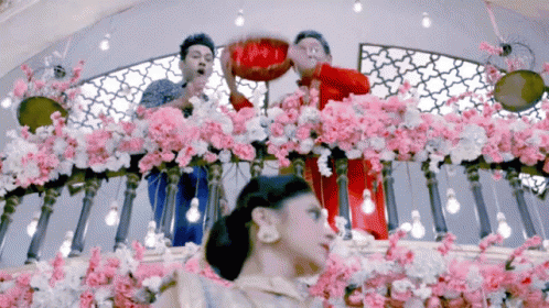 two women and three men are surrounded by flowers and balloons