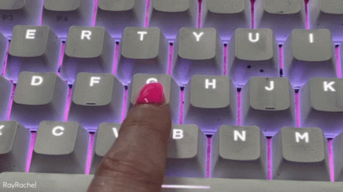 a purple keyboard with white letters is highlighted by the hand