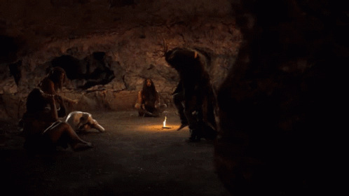 the scene shows several people inside a dark cave with glowing items