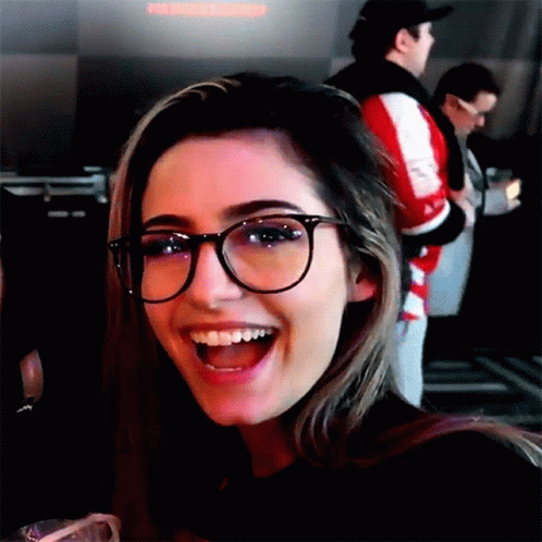 a girl with glasses and a big smile