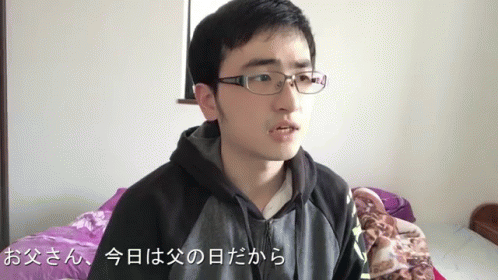 a young asian man wearing glasses, staring at the camera
