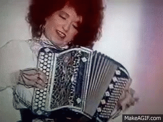 a woman is holding an accordion in her hand