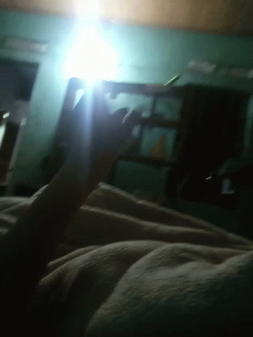 someone is in bed with a cell phone and looking at the light coming out of their hand