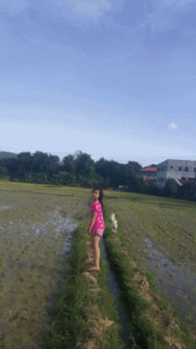 a woman that is walking in the grass