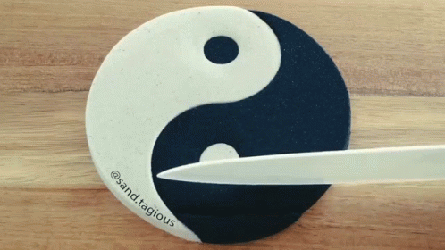 a pair of scissors in front of a logo that is yin yang